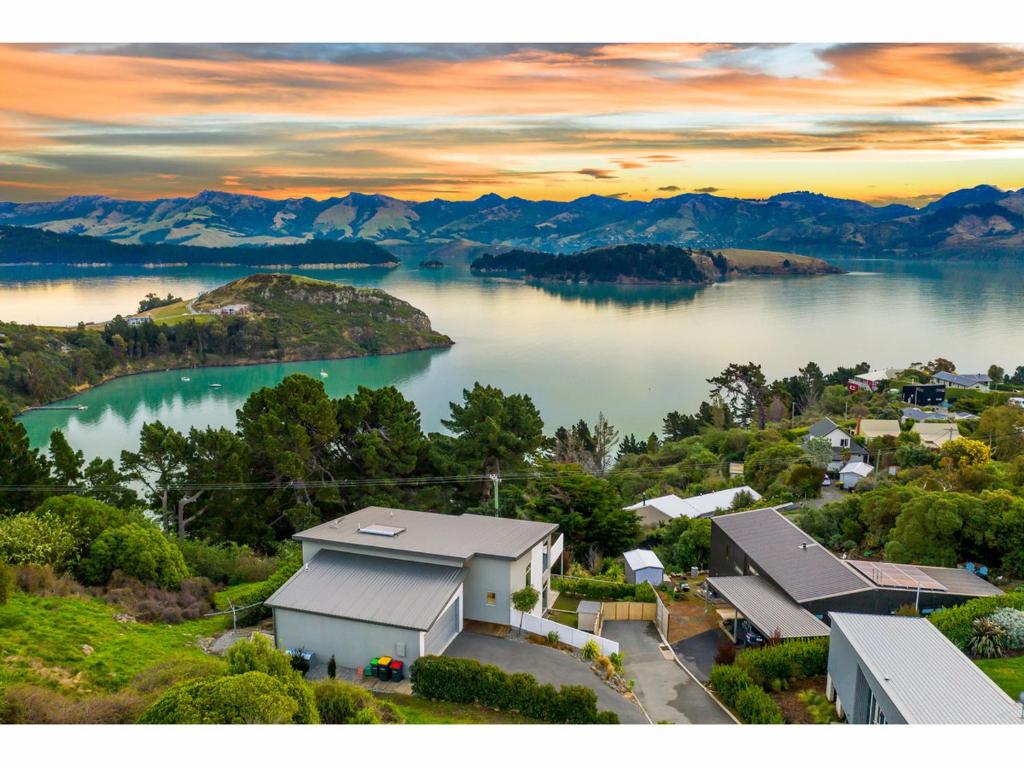 基督城Diamond Harbour Hidden Gem的湖岸房屋的空中景观