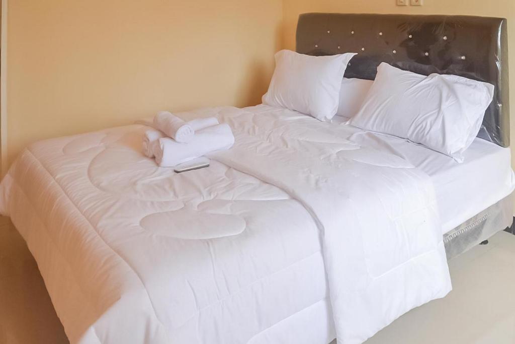 茉莉芬Artayya Puri Homestay near Terminal Purabaya Madiun Mitra RedDoorz的白色的床、白色床单和枕头