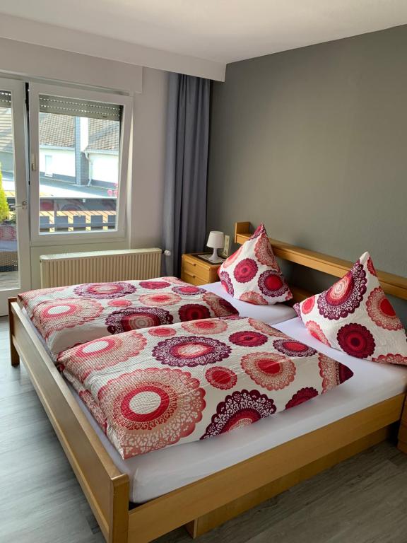 Mannebachvina am ring的一间卧室配有一张带红白毯子和枕头的床