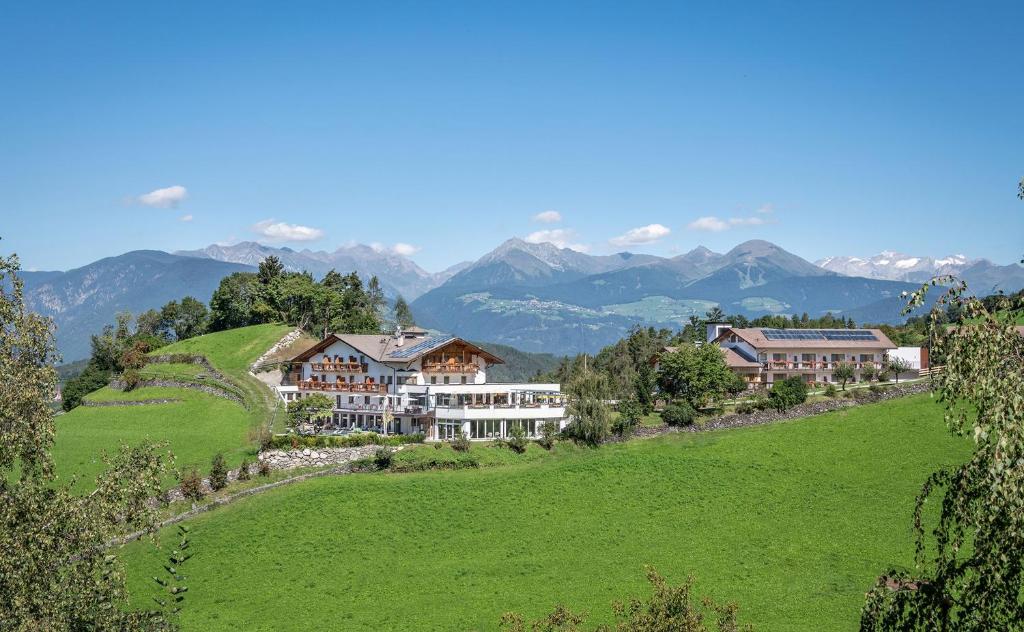 布列瑟农Hotel Torgglerhof的山丘上的度假村,以山脉为背景
