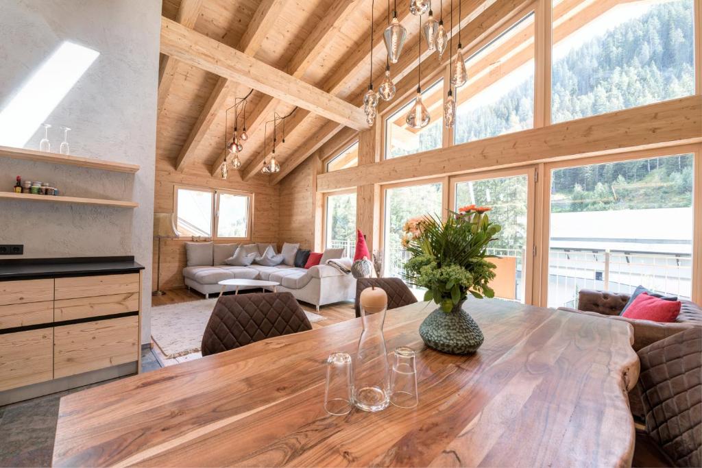 圣安东阿尔贝格Quality Hosts Arlberg - ALPtyrol Appartements的厨房以及带木桌和椅子的用餐室。