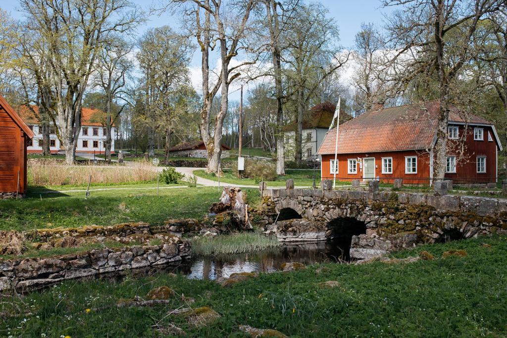 ÅråsÅrås Kvarn & Hostel的一座桥,在红楼旁的一条河上