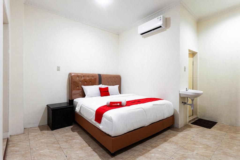 棉兰RedDoorz near Yuki Simpang Raya Mall Medan 2的一间卧室设有一张大床和一个水槽