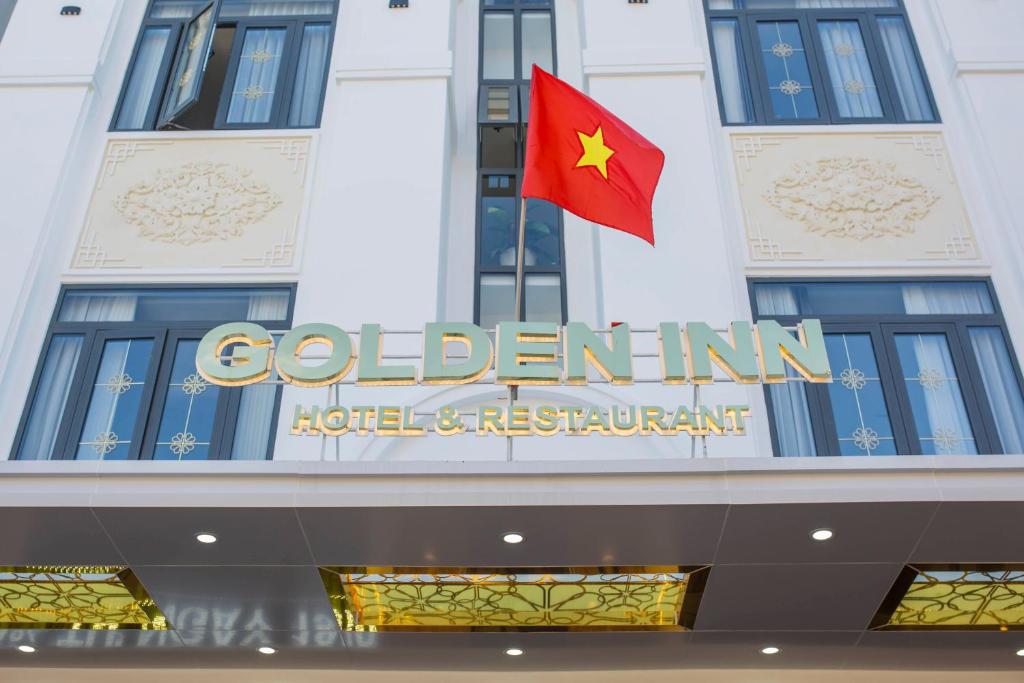 顺化Golden Inn Hotel的建筑物顶部的旗帜,有标志