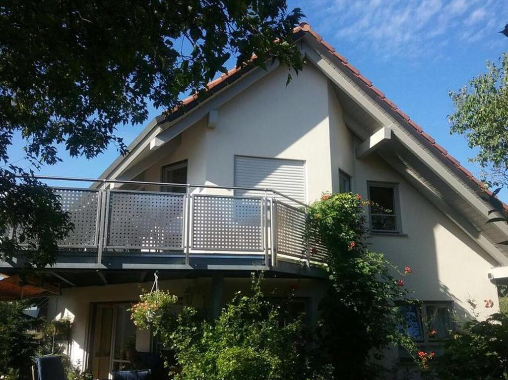 莫斯Ferienwohnung Ingeborg Schmitz的白色房子的一侧设有阳台