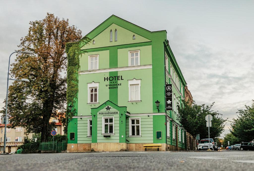 伊钦Hotel U Valdické brány的街道拐角处的绿色白色建筑