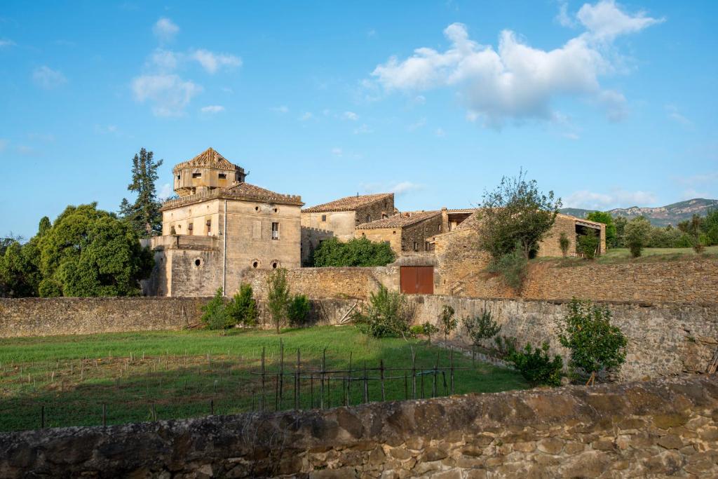 Canet de AdriCa n'Heras的石墙旁田野上的古老建筑
