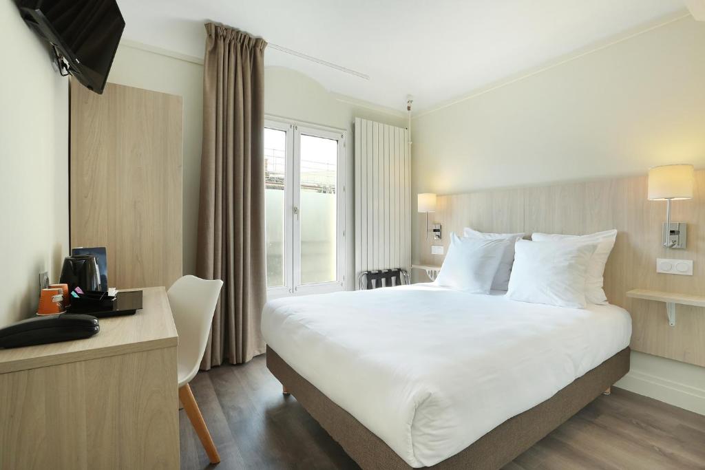巴黎穆拉酒店的一间设有大床和窗户的酒店客房