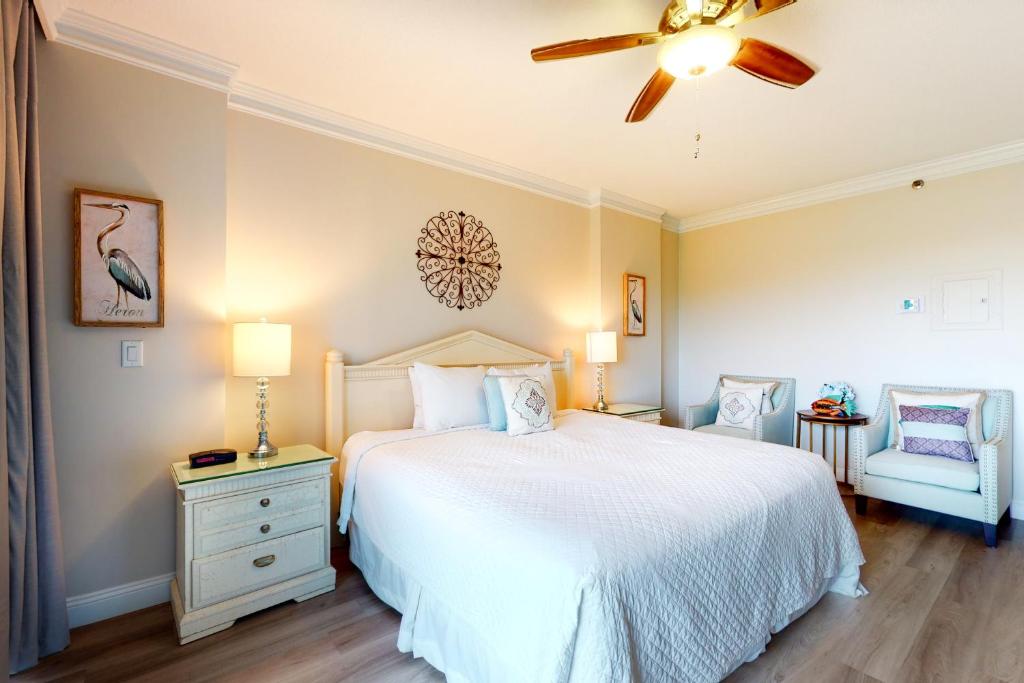 德斯坦TOPS'L Summit II的卧室配有白色的床和吊扇