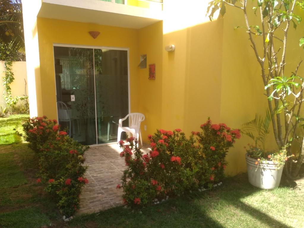 因巴塞Casa em Imbassai的院子里有椅子和鲜花的房子
