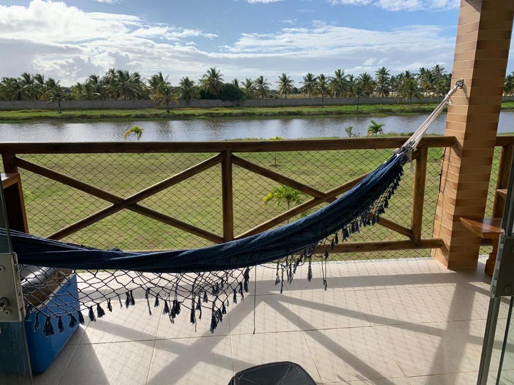 埃斯坦西亚Condomínio e resort Villa das Águas - Praia do Saco SE的湖景门廊上的吊床