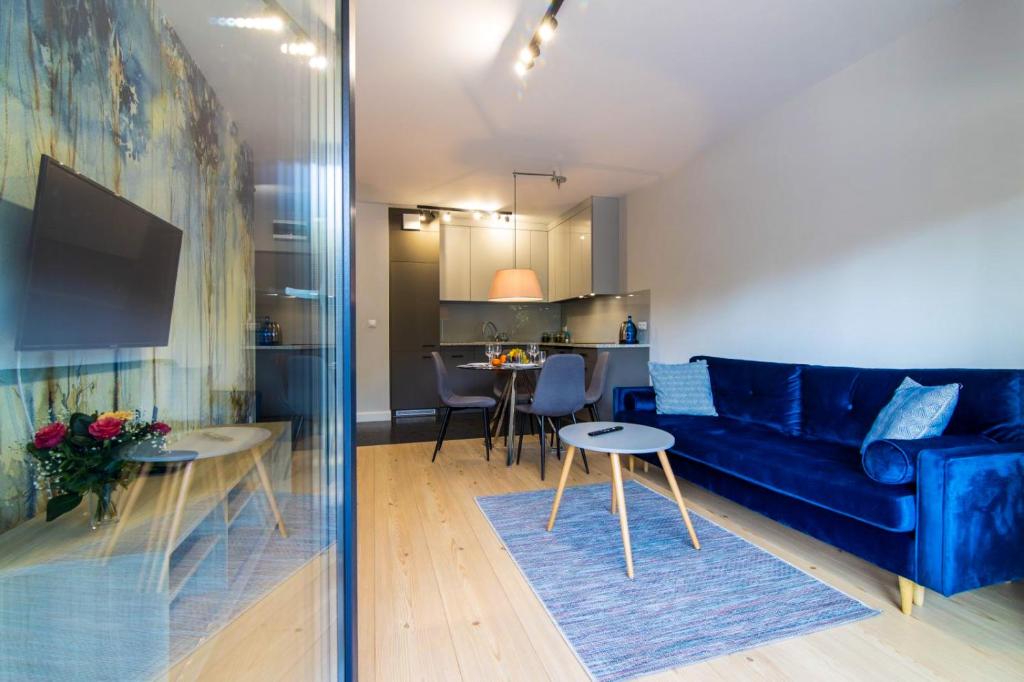 比亚韦斯托克Apartament Koncertowy的客厅配有蓝色的沙发和桌子