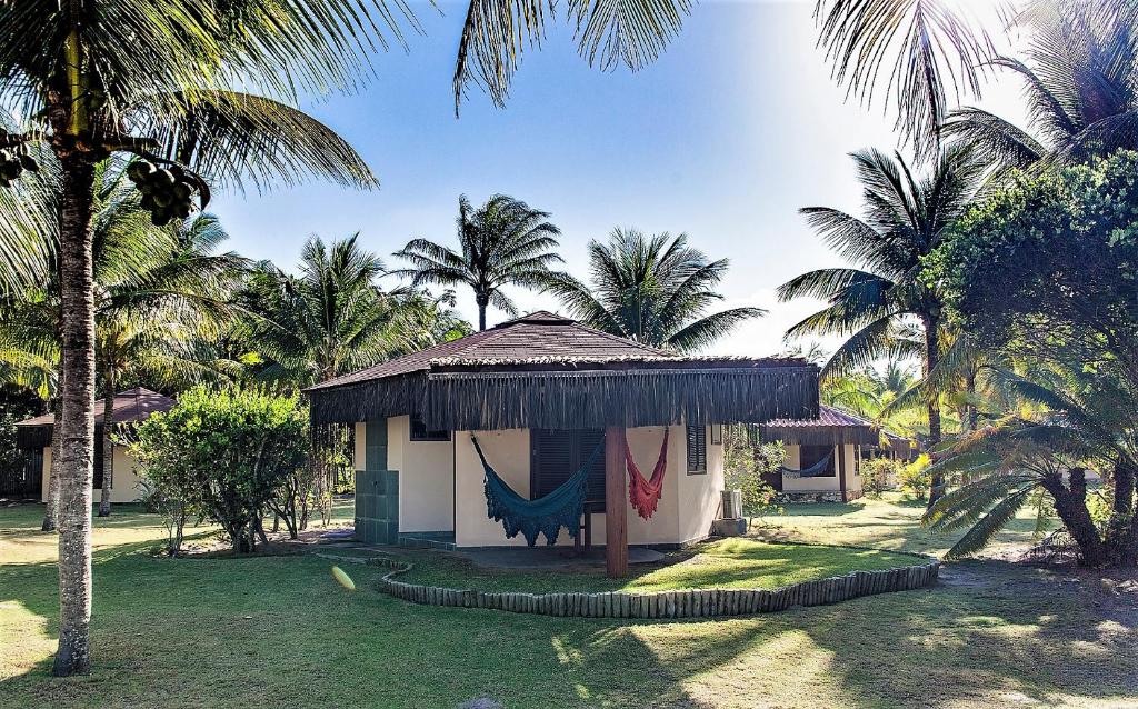 马劳拉格亚卡三吉旅馆的棕榈树庭院内带吊床的小小屋