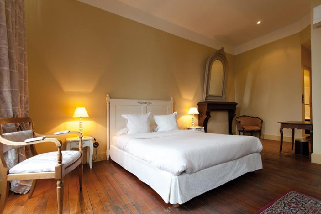 容扎克杜克迪欧酒店的卧室配有一张白色大床和一把椅子