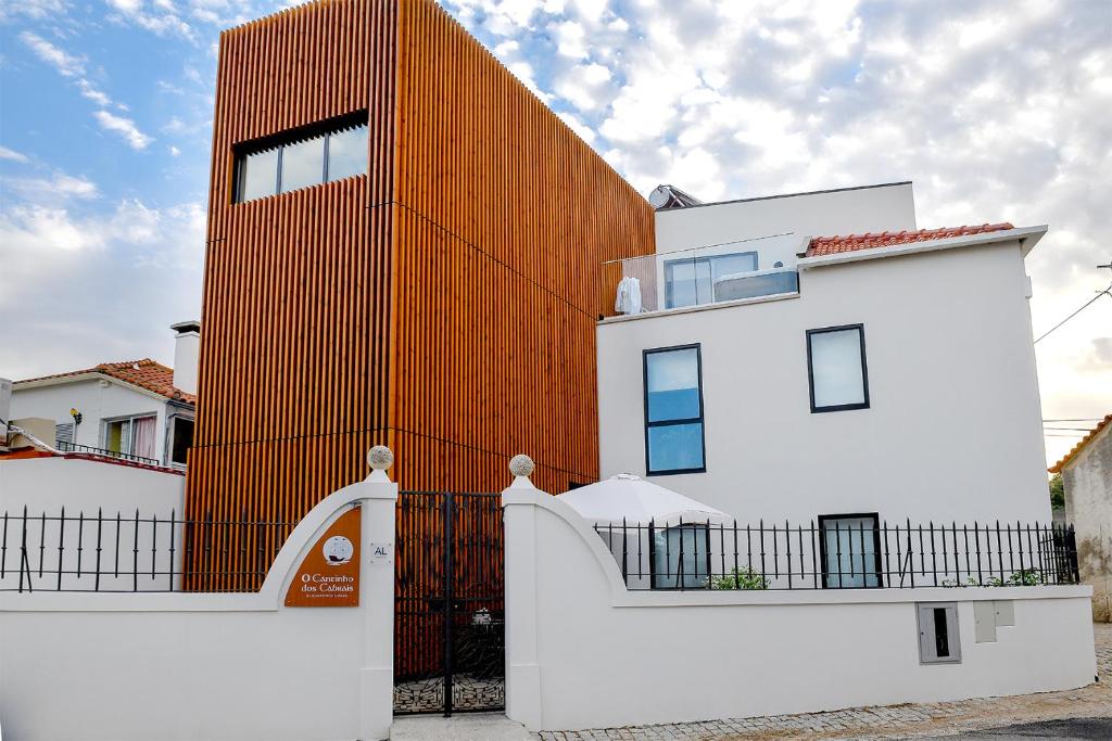 InguiasO Cantinho dos Cabrais的围栏后面有橙色墙的建筑