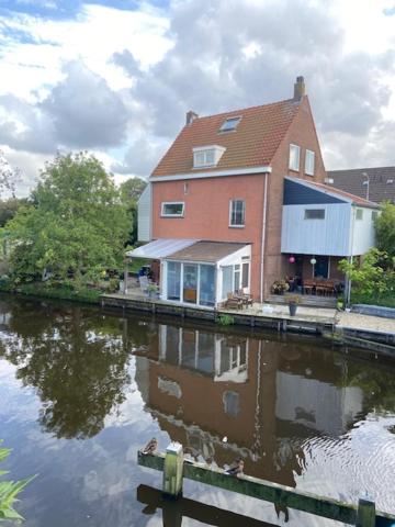 赞丹Characteristic detached house next to water的水边的房子