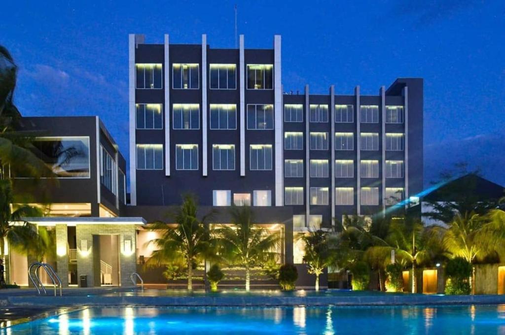 哥伦打洛省ASTON Gorontalo Hotel & Villas的大楼前设有游泳池的酒店