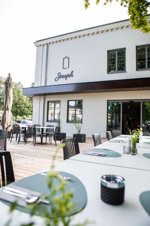 布如克纽多夫Hotel Restaurant Joseph的大楼前设有桌椅的餐厅