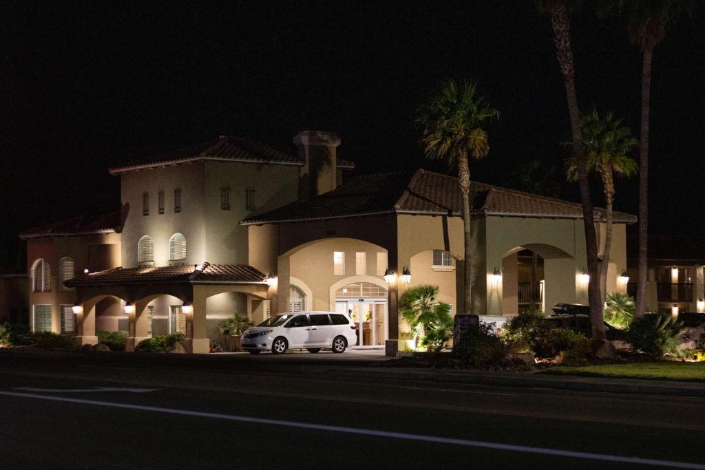 金曼贝斯特韦斯特普拉斯旅行酒店及套房的夜间停在房子前面的白色汽车
