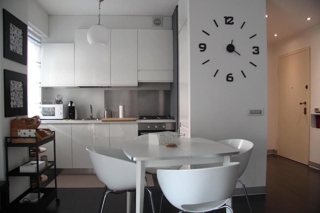 蒂拉诺Civico6的厨房配有桌子和墙上的时钟