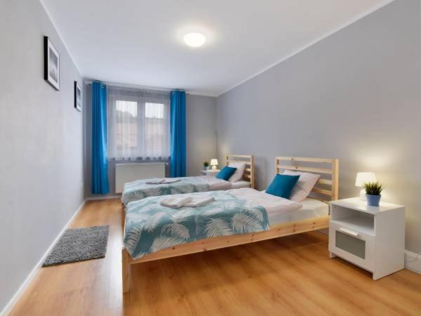 杜什尼基-兹德鲁伊Apartament w Mieście的一间卧室配有2张蓝色窗帘