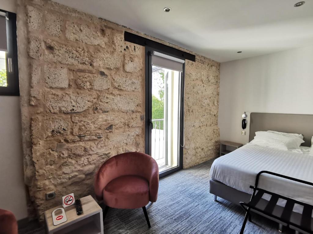 艾克斯莱班德拉库罗讷酒店的一间卧室设有一张床和砖墙