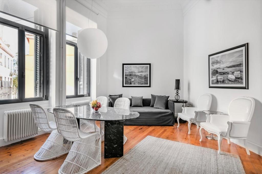 雅典Art Pantheon - Suites & Apartments的客厅配有桌椅和沙发