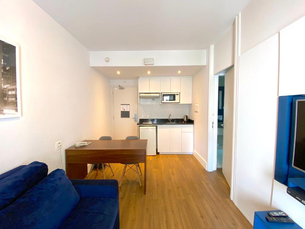 圣保罗Apartamento conforto - Itaim Bibi的客厅配有蓝色的沙发和桌子
