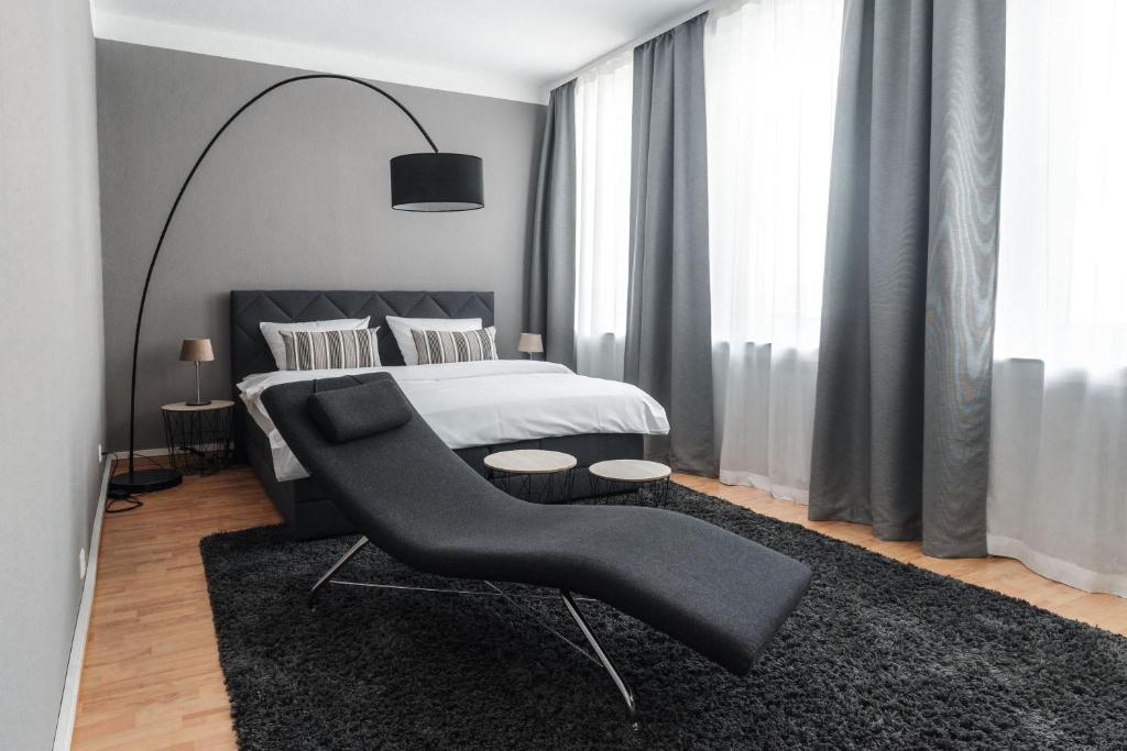 明斯特Stylisches Münster City-Apartment 83 m²的一间卧室配有一张床和一张黑椅