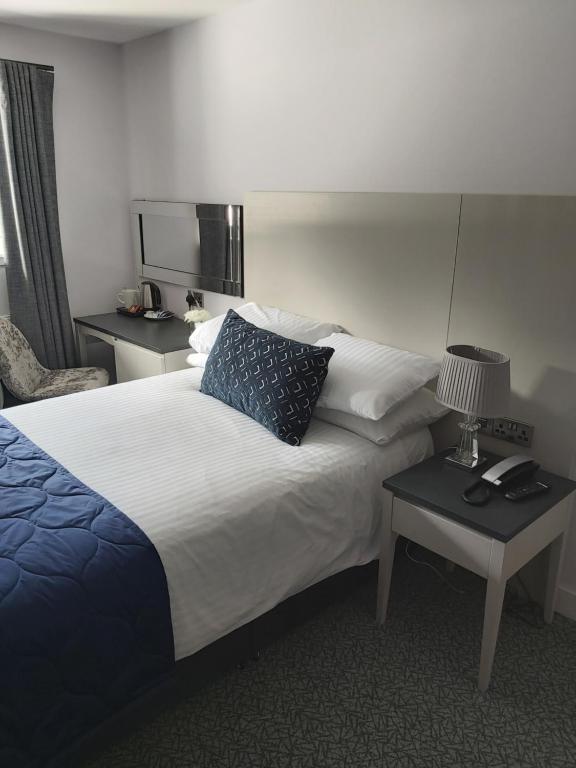 柯科迪迪恩公园酒店的酒店客房设有一张大床和两张桌子。