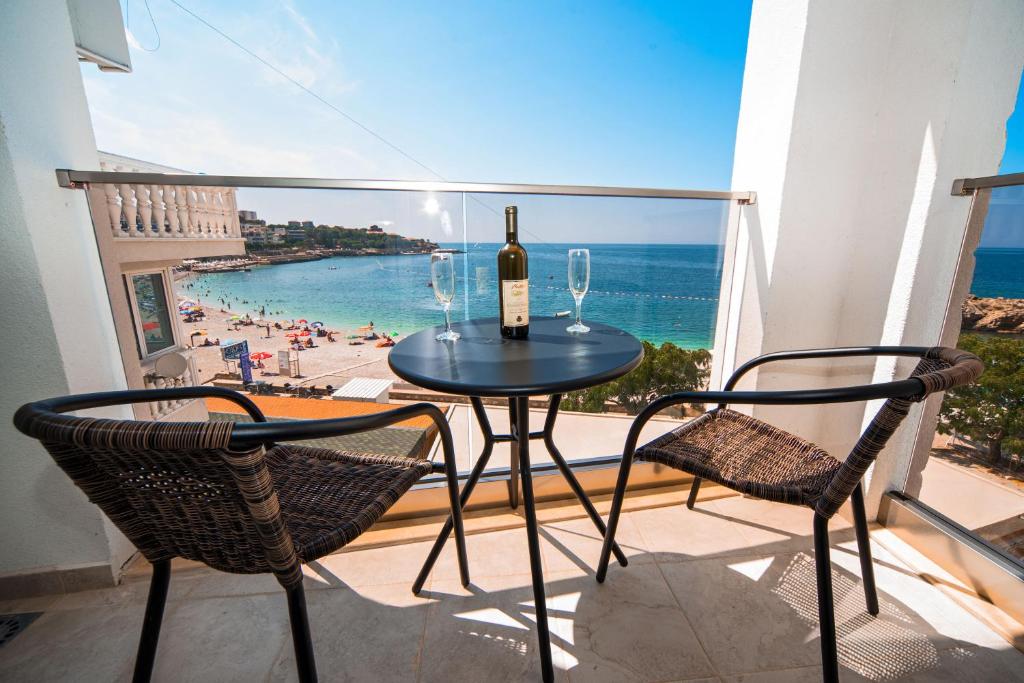 多布拉沃达David Lux beach rooms的一张桌子、一瓶葡萄酒和两把椅子