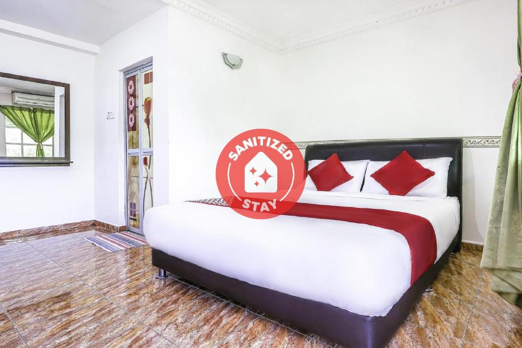 TangkakD' Anjung Inn的一间卧室,配有一张带标志的床