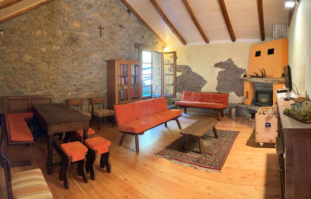 MuzzanoBBB Bed&Breakfast Bagneri的客厅设有桌椅和石墙