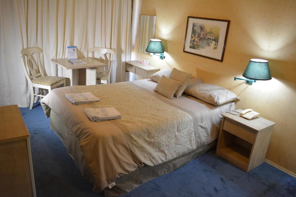萨尔托Hotel Solar del Acuario的酒店客房,配有一张床和两张桌子及椅子