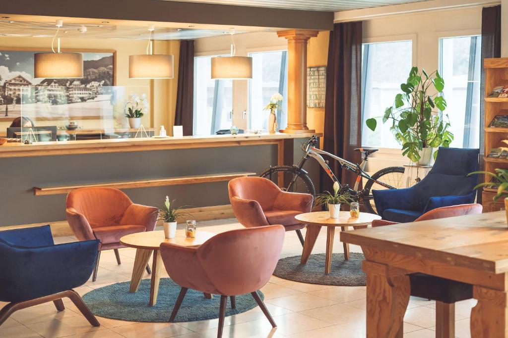 施坦斯Tailormade Hotel STANS SÜD的一间带桌椅和柜台的餐厅