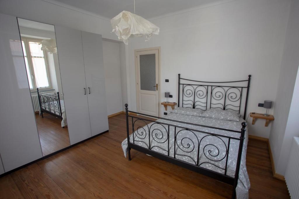 托雷佩利切Appartamento con vista a Torre Pellice的一间设有一张床铺的卧室,位于一个带镜子的房间