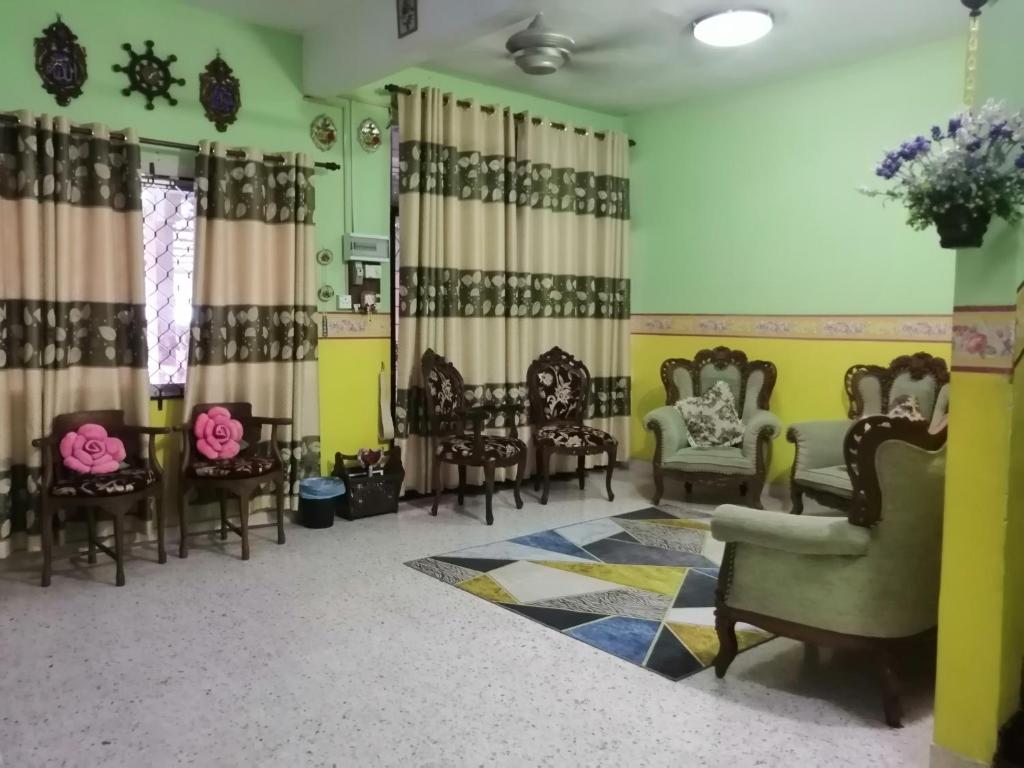 居銮KLUANG BARAT HOMESTAY的客厅配有椅子和桌子