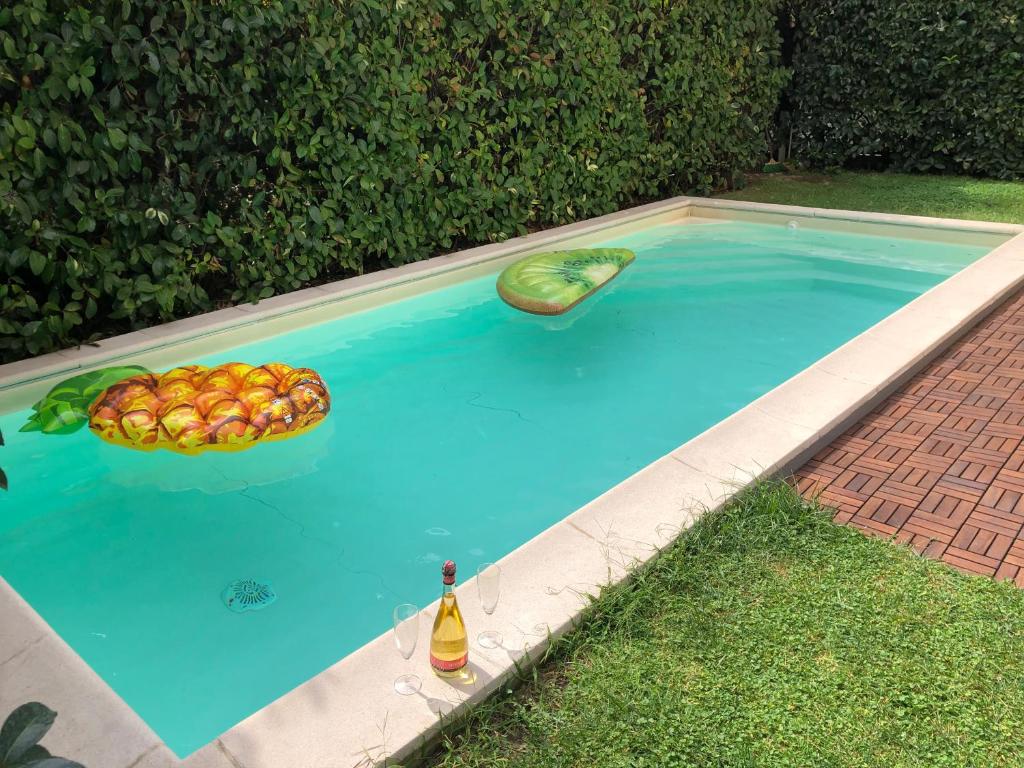 那不勒斯Villa Capri Apartment and Room的游泳池里的水果碗和一瓶