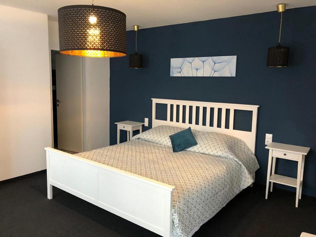 SeebensteinPension zum Spitz的卧室配有白色的床和蓝色的墙壁