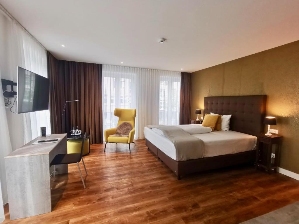 斯图加特H23 Hotel Stuttgart的酒店客房,配有一张床、一张桌子和椅子