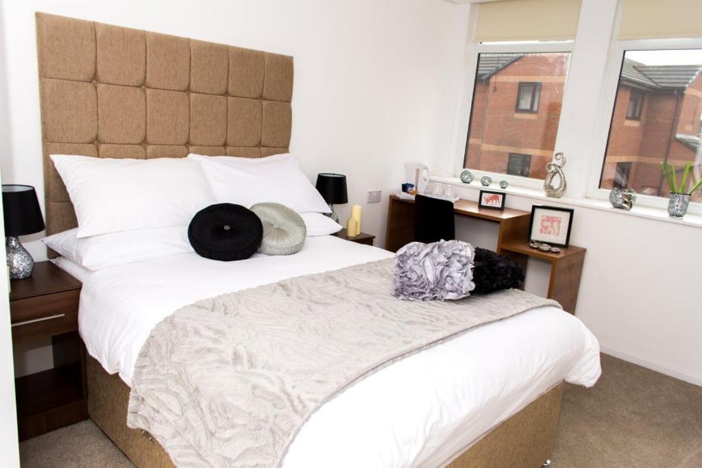 曼彻斯特Parkview Residence的一间卧室配有一张大床,上面有两顶帽子