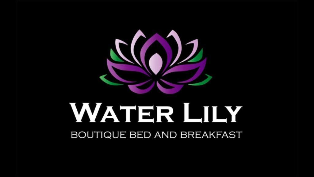 赫维兹Water Lily Boutique B&B and Bungalow的黑色背景上的紫色百合标志