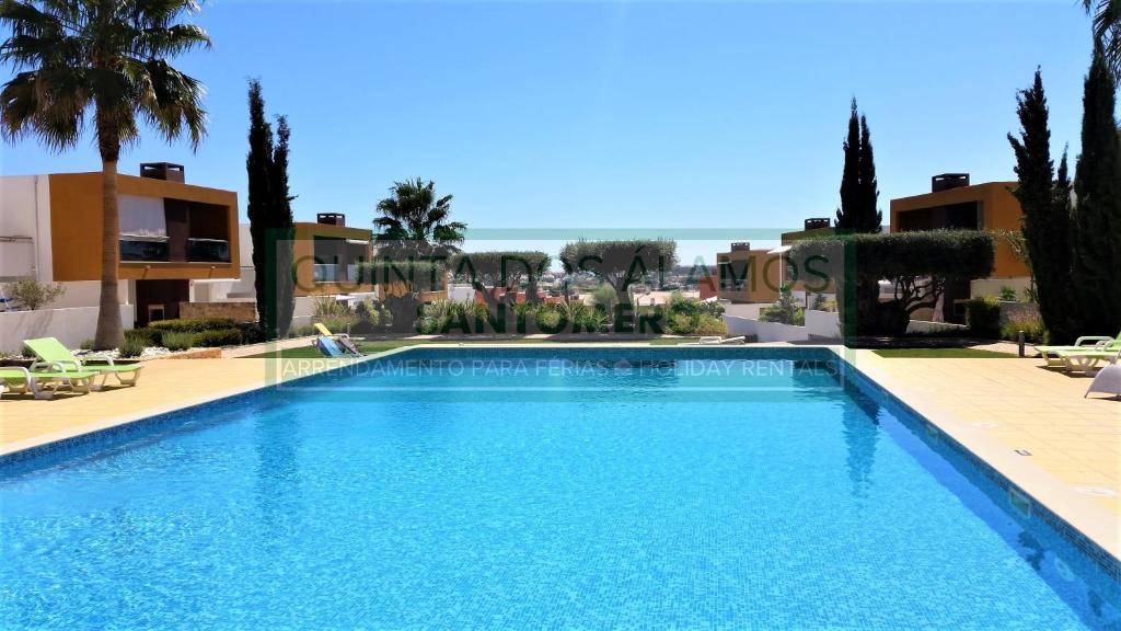吉亚Apartamento Vitismar CA的棕榈树和建筑度假村内的游泳池