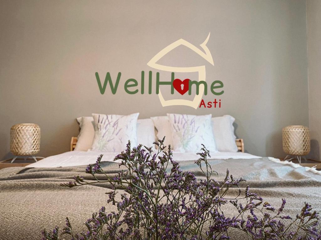 阿斯蒂WellHome的卧室配有一张床铺,墙上有健康标志