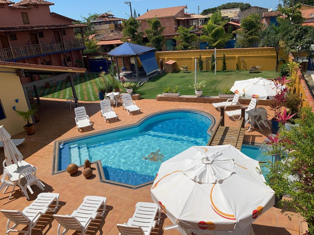 伊塔乌纳斯珊瑚旅馆的游泳池旁设有椅子和遮阳伞