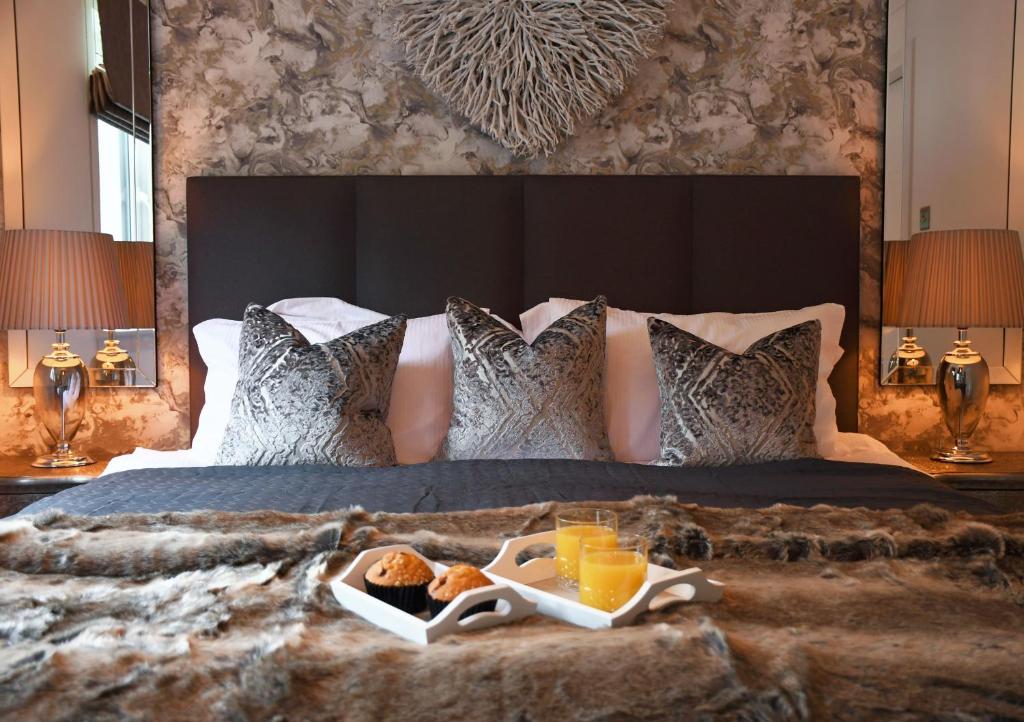 奥赫特拉德Gleneagles Luxury Apartment的一张床上放着食物的托盘