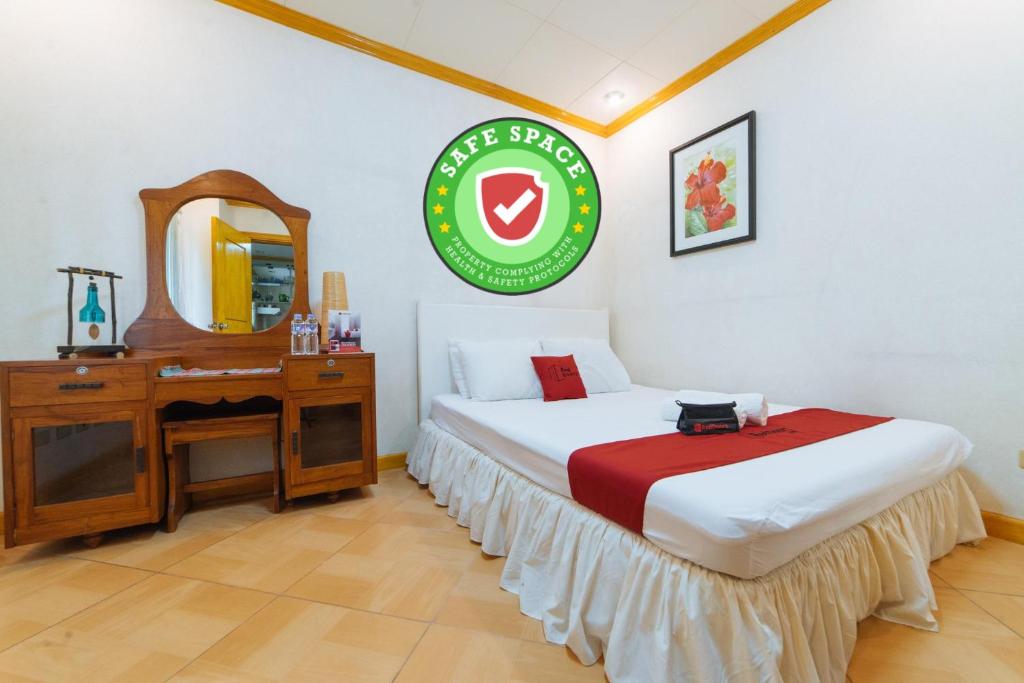 黎牙实比RedDoorz @ Arimbay Legazpi City的一间卧室配有一张床、一张书桌和一面镜子