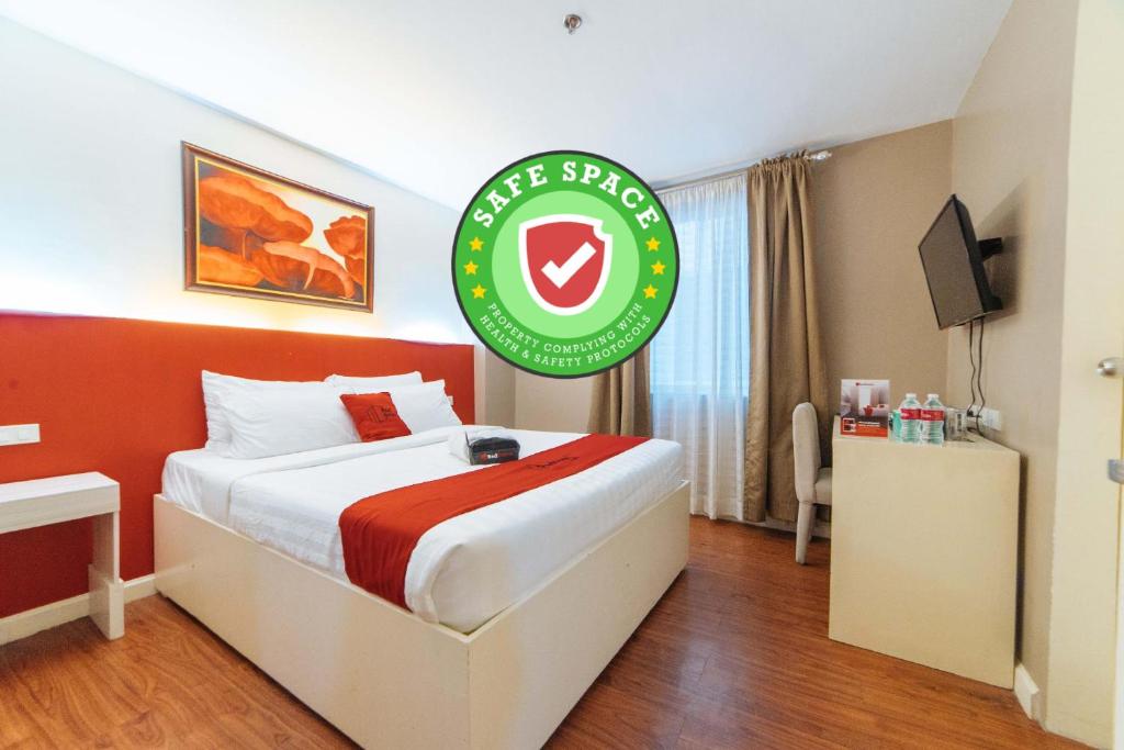 卡利博RedDoorz Plus at Hotel Metro Kalibo的酒店客房,配有一张带标志的床