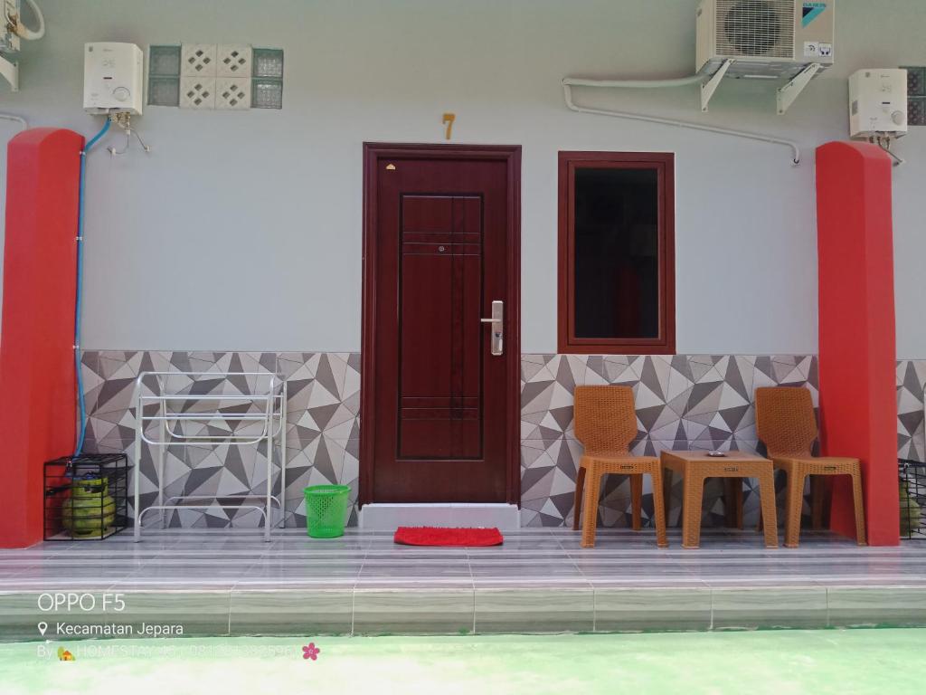 哲帕拉Homestay Premium 45的一间设有两把椅子和红色门的房间