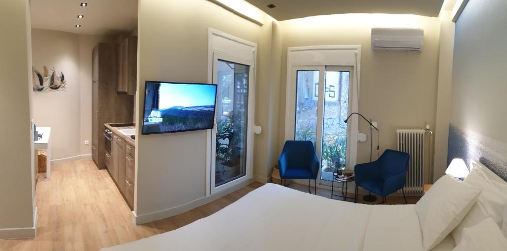 雅典Renovated Studio with Roof Garden access, 15 m walk to Acropolis的一间卧室配有一张床和一台平面电视